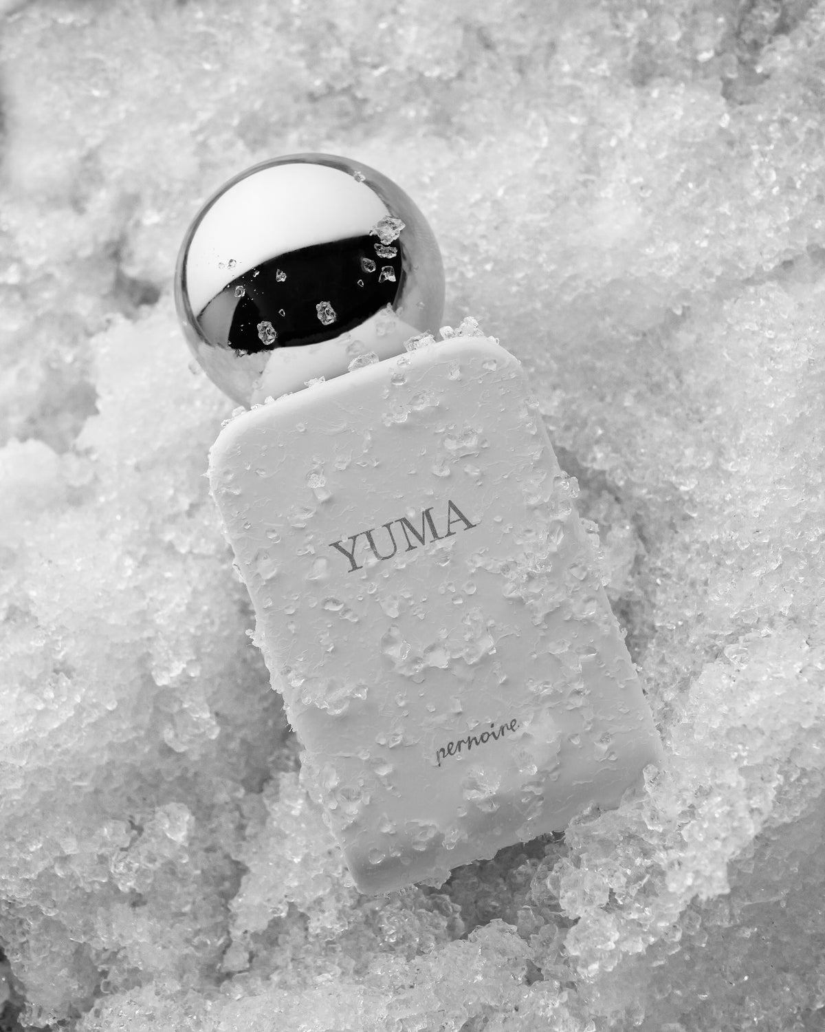 White YUMA bottle resting on bright crushed ice and snow.